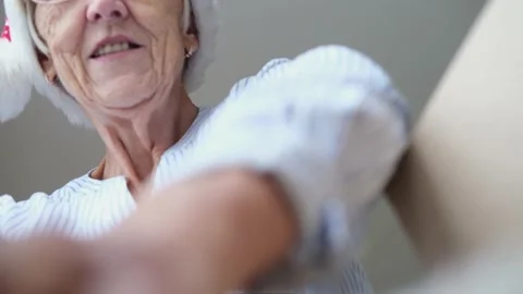 Close up inside of carton box bottom view, elderly woman wearing christmas hat Video stock 159970095