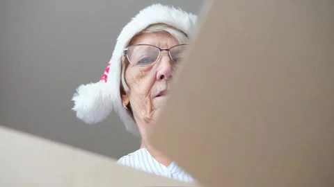 Close up inside of carton box bottom view, elderly woman wearing christmas hat Stock Footage 282084205