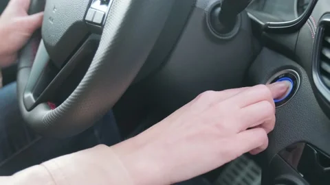 Close up inside modern car, a woman's hand presses the engine start button. The Stock Footage 154004324