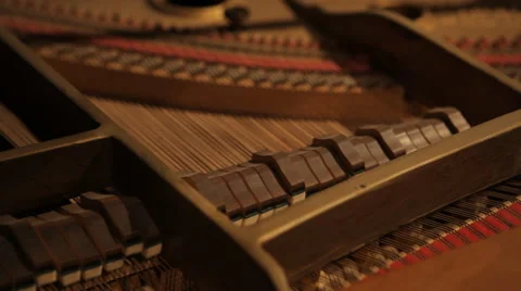 Close up of inside retro piano's hammers striking strings Stock Footage 60527375