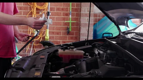 Close Inspection of Engine Oil Dipstick by Man in Garage Stock Footage 331508751