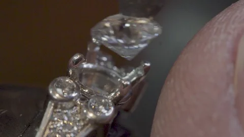 Close up installing a diamond into a ring crown Stock Footage 82400311