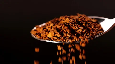 Close-up of instant coffee pieces falling from spoon in slow motion Stock Footage 125963328
