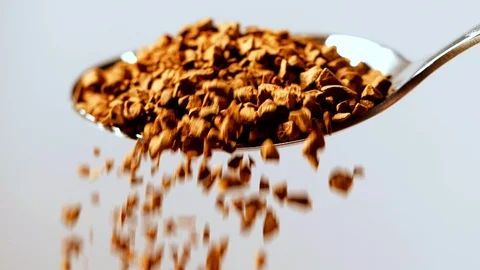 Close-up of instant coffee pieces falling from spoon in slow motion Stock Footage 125963334