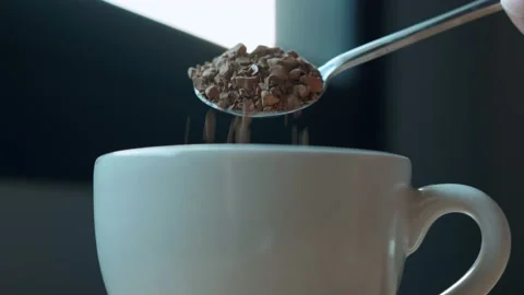 Close-up of instant coffee pieces falling from spoon in slow motion Stock Footage 151614797