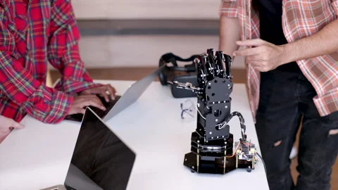 Close-up instructor hands demonstrate how robotics hand work, group of youn.. Stock Footage 245059732