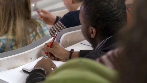 Close-up of intelligent student taking notes about the topic Stock Footage 69929005