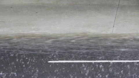 Close up of intense rain drops falling and splashing on a wet asphalt street Stock-Footage 342623635