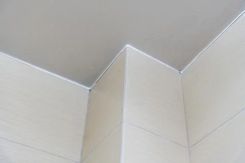 Close-up of an interior corner showcasing a transition between a beige wall and Stock-Fotos