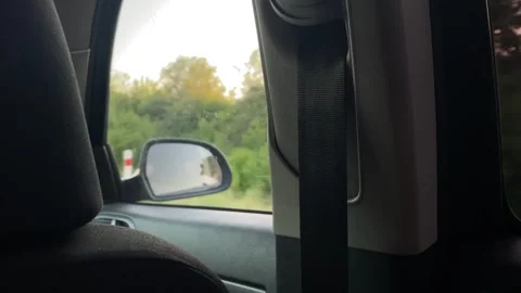 Close interior view of b-pillar and seatbelt with passing roadside visible car Stock Footage 344586786