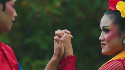 Close-Up of Intertwining Hands and Intimate Gaze of Indonesian Dancers Stock Footage 278583402