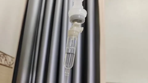 Close-Up of Intravenous (IV) Drip Administering Saline Solution in Hospital Video stock 292430352