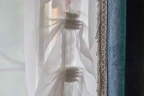 Close-up of intricately patterned lace curtains, lit by sunlight, displaying  Stock Photos