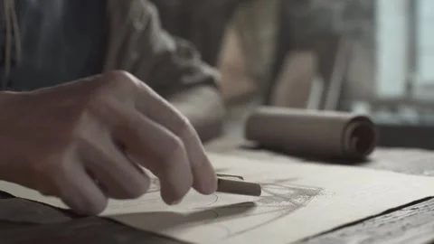 Close up of inventor hands sprinkling sand with a scoop on a wing blueprint Stockbeeldmateriaal 340079836