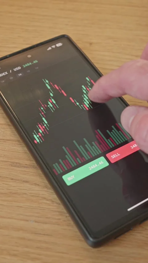 Close-up of a investor using a smartphone trading app to analyze candlestick Stock Footage 341860502
