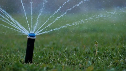 Close-up. Irrigation system. Water splashes are sprayed on the manicured lawn Stock Footage 129068805