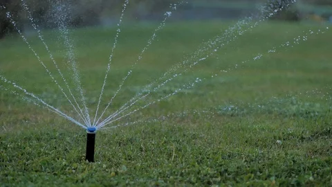 Close-up. Irrigation system. Water splashes are sprayed on the manicured lawn Stock Footage 129068813