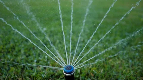 Close-up. Irrigation system. Water splashes are sprayed on the manicured lawn Stock Footage 129068851