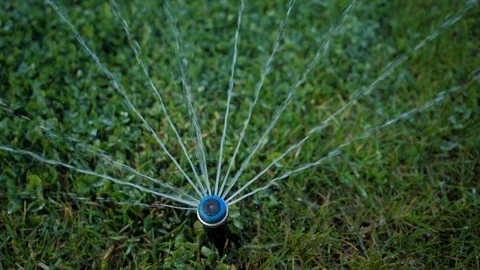 Close-up. Irrigation system. Water splashes are sprayed on the manicured lawn Stock Footage 129068852