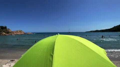 Close-up of Isolated green beach umbrella and people in background Stock Footage 219986646