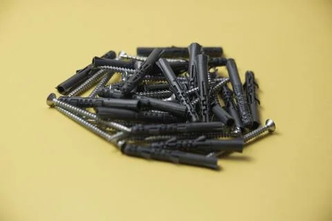 Close up isolated image of sets of gray plastic dowels plugs and shiny metal  Фото