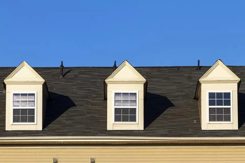 Close up isolated image of three false dormer windows (gabbled style) on a sh Stock Photos