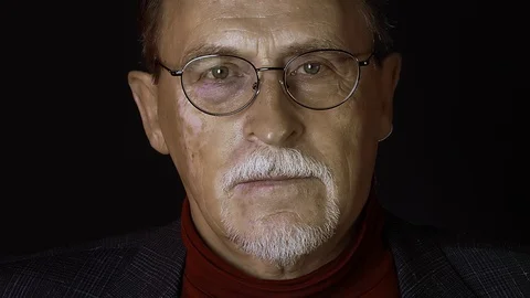 Close up isolated portrait of senior man in glasses on black background Stock Footage 129194810