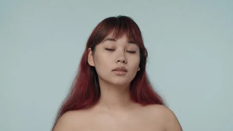 Close-up isolated slow motion video of a young seminude woman with red dyed hair Stock Footage 251740770