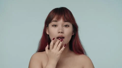 Close-up isolated slow motion video of a young seminude woman with red dyed hair Stock Footage 251740918