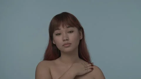 Close-up isolated slow motion video of a young seminude woman with red dyed hair Stock Footage 251760189