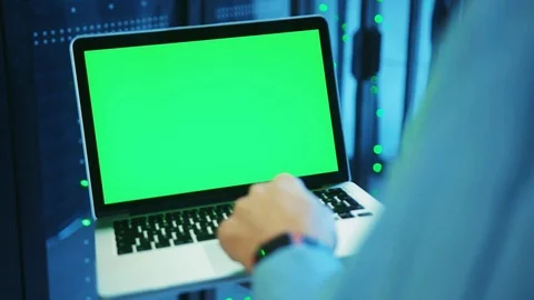 Close-up IT admin holding a mock-up chroma key green laptop at server racks Stock Footage 121116142