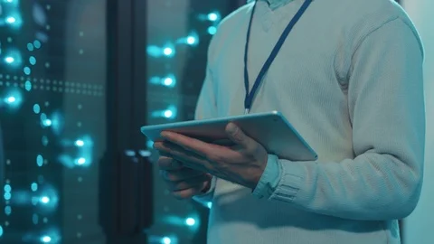Close-up IT administrator holding tablet inspecting operational server rack Stock Footage 119233620