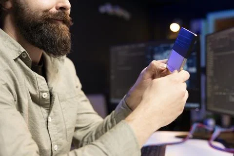 Close up of IT expert inserting disk into desktop PC containing AI data Foto stock