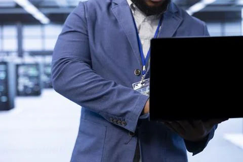 Close up of IT expert in server hub looking for technical issues using notebook 스톡 사진