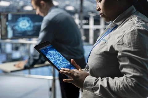 Close up of IT professional in server farm using tablet to improve AI systems Stock Photos