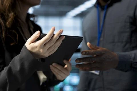 Close up of IT staff members using device to review firewall rules 스톡 사진