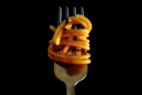 Close up of Italian Spaghetti on a fork with tomato sauce on black background Stock Photos