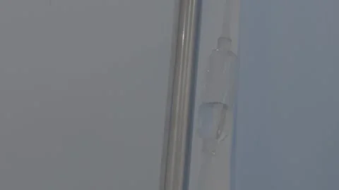 Close-Up of IV Drip Chamber Dripping Saline Solution Stock Footage 345471087