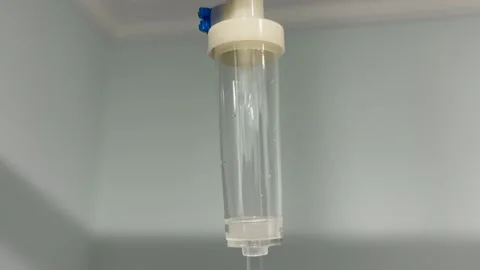 Close-up of IV drip chamber with liquid flowing Video stock 344690116