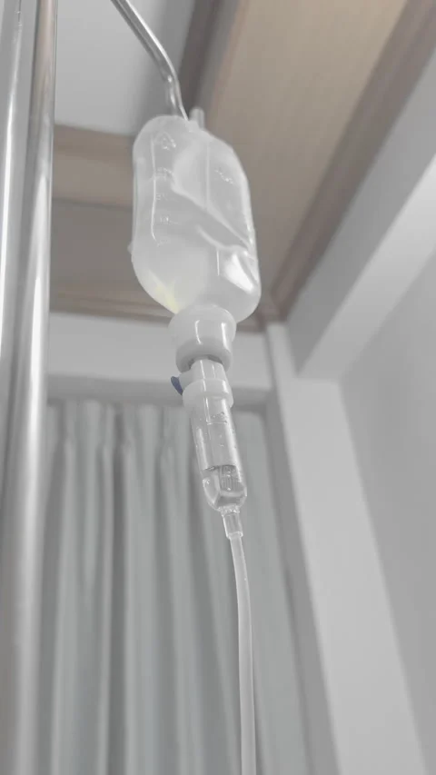 Close Up IV Drip Normal Saline Flow in Hospital Medical Treatment Setting Stock Footage 329677749