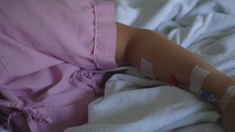Close up IV drip solution in a patient's hand while lying on bed in hospital. Stock-Footage 103193527