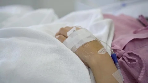 Close up IV drip solution in a patient's hand while lying on bed in hospital. Stock-Footage 103194530