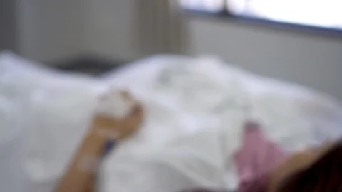 Close up IV drip solution in a patient's hand while lying on bed in hospital. Stock-Footage 103194886