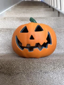 Close up of a jack-o-lantern pumpkin on carpeted stairs Stock Photos