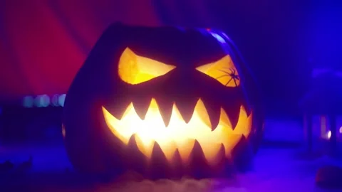 Close-up of a Jack O'Lantern lantern in blue light emitting smoke Stock Footage 217368858