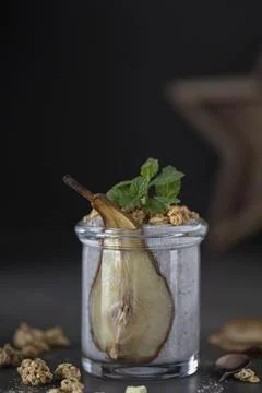 Close up of jar chia seed pudding decorated with slice of dried pear, granola Stock Photos