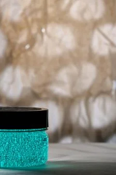 Close-up of a jar of cosmetics on an abstract background. Turquoise gel. Sele Stock Photos