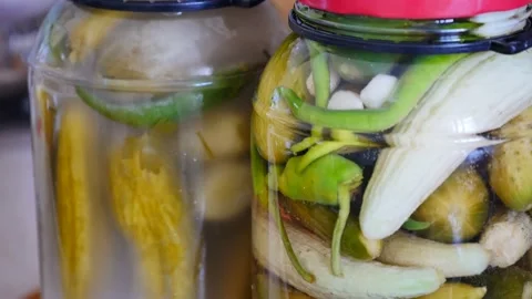 Close-up jars of ripe pickles and unripe pickles are standing side by side, Video stock 137765105