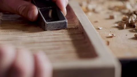 Close up. a joiner processes the walnut board with a small planer. artisan ma Stock Footage 144244273
