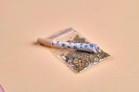 Close-up joint and packet of weed isolated on beige background. Close-up j... Fotos de archivo